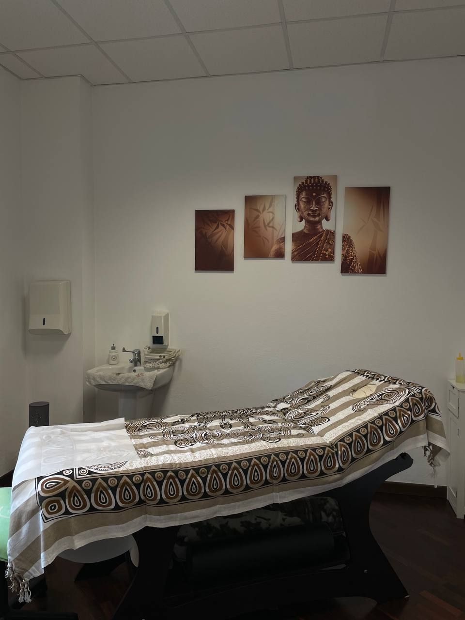 Il lettino della sala trattamenti con i quadri alla parete